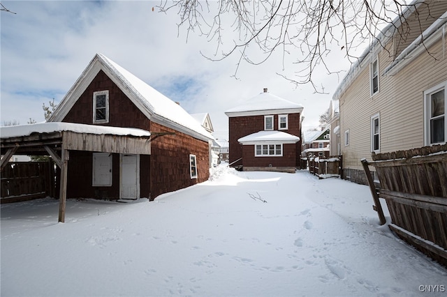 view of snow covered back of property