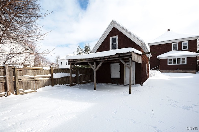 snow covered house featuring an outdoor structure