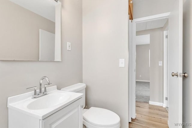 bathroom featuring hardwood / wood-style flooring, vanity, and toilet