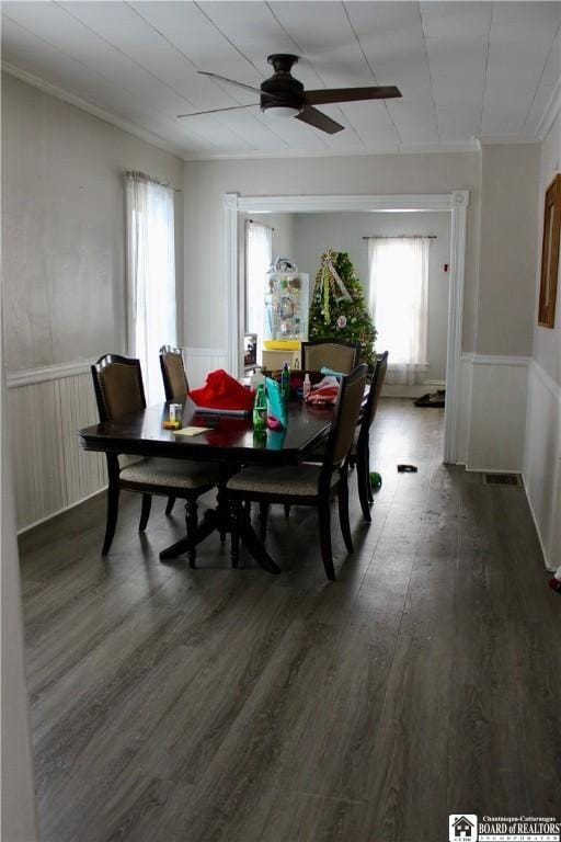 dining room featuring dark wood-type flooring, ornamental molding, and ceiling fan