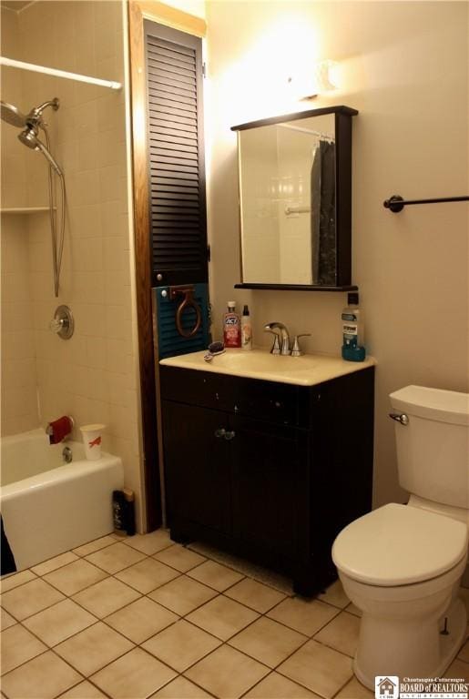 full bathroom featuring vanity, tiled shower / bath, tile patterned floors, and toilet