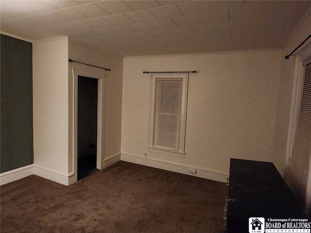 unfurnished room featuring crown molding and dark colored carpet