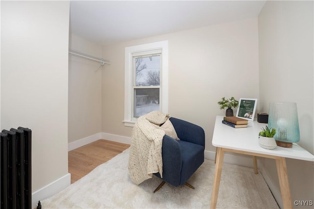 sitting room with wood-type flooring and radiator