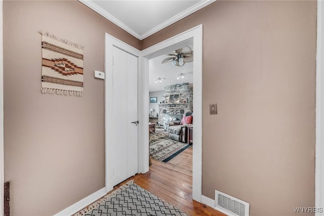 corridor with hardwood / wood-style floors and crown molding