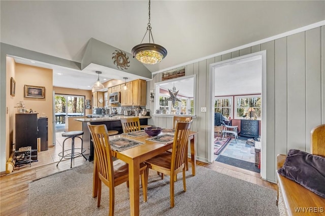 dining area featuring lofted ceiling and light hardwood / wood-style floors