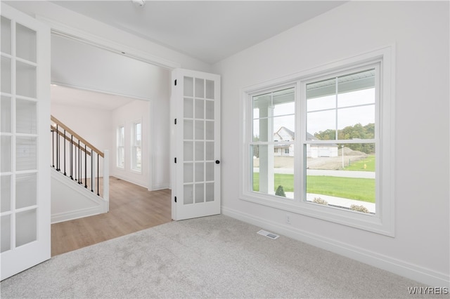 empty room with light colored carpet and french doors