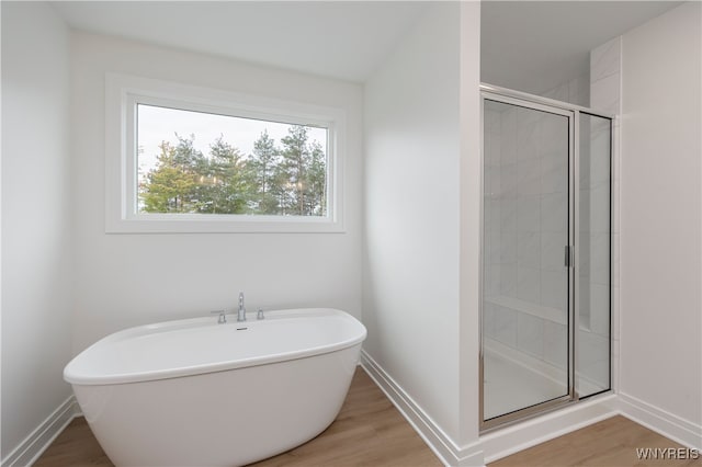 bathroom with independent shower and bath and hardwood / wood-style flooring