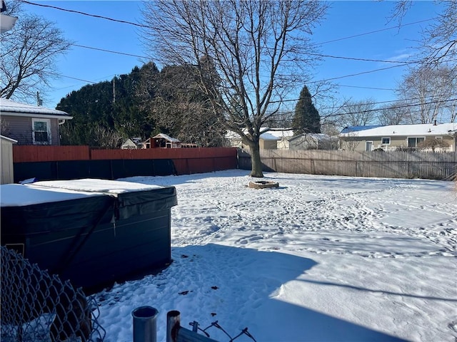 yard layered in snow with a hot tub