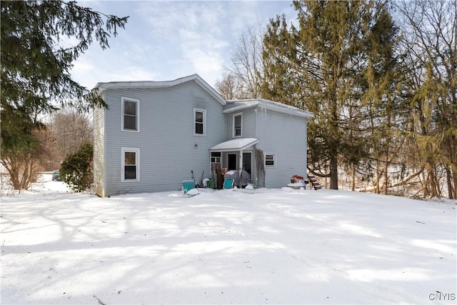 view of snow covered rear of property