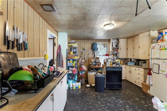 kitchen with dishwasher, white fridge, light brown cabinets, and wooden walls