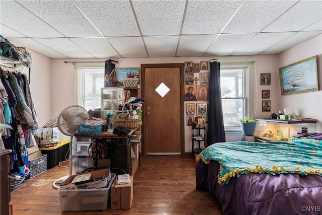 bedroom featuring a drop ceiling and hardwood / wood-style floors