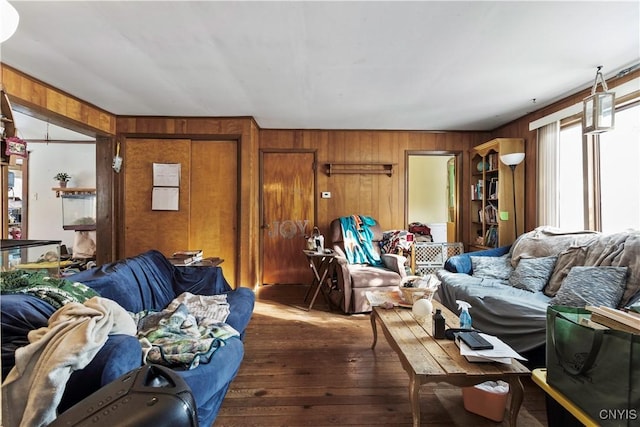 living room featuring dark wood-type flooring and wood walls