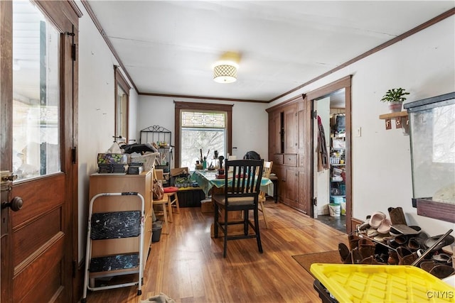 dining space with ornamental molding and hardwood / wood-style floors