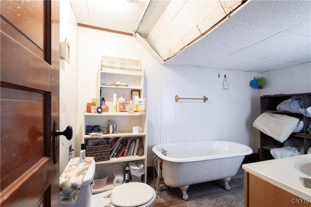 bathroom featuring vanity, a tub to relax in, and toilet