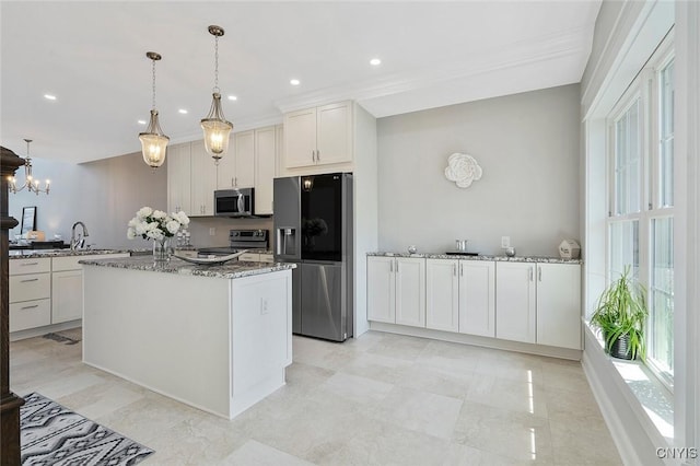 kitchen featuring white cabinetry, appliances with stainless steel finishes, hanging light fixtures, and dark stone countertops