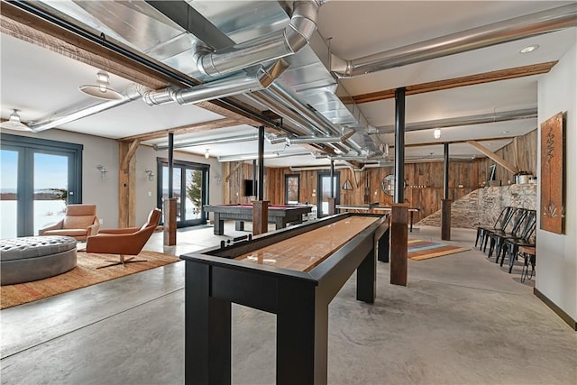 playroom with wood walls, french doors, finished concrete flooring, and billiards