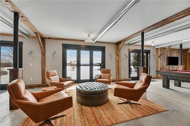 living area with beam ceiling, french doors, concrete floors, pool table, and baseboards