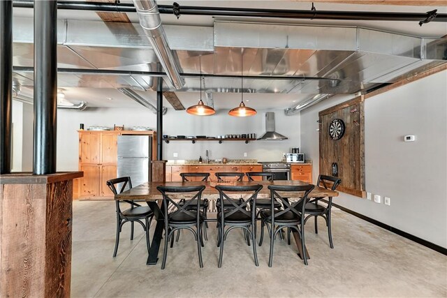 dining space with concrete flooring and baseboards