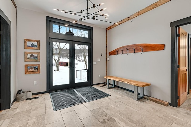 entrance foyer featuring french doors, baseboards, and a chandelier