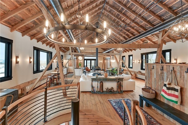 interior space featuring a wealth of natural light, a notable chandelier, lofted ceiling with beams, hardwood / wood-style floors, and wood ceiling