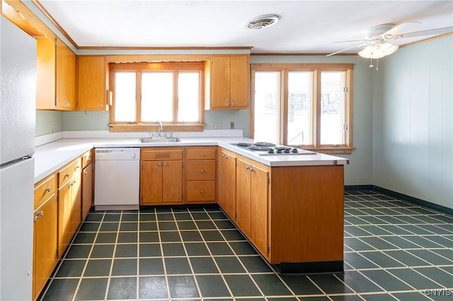 kitchen with sink, white appliances, kitchen peninsula, and ceiling fan