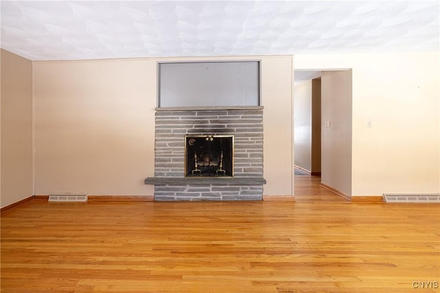 unfurnished living room featuring light wood-type flooring and a fireplace