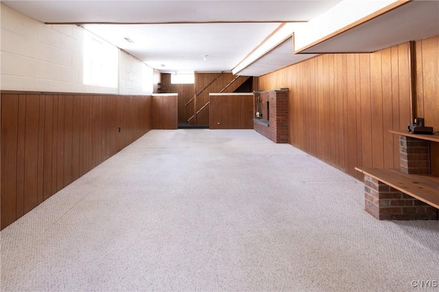 basement featuring carpet floors and wooden walls