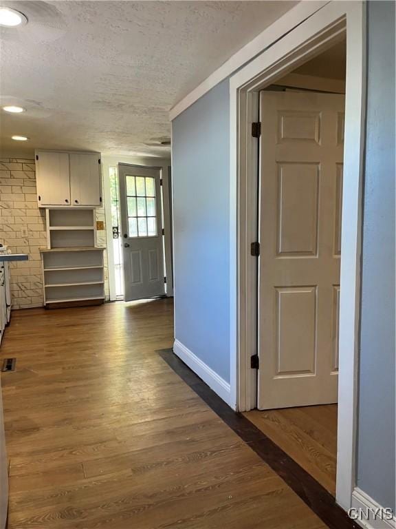 hallway featuring dark hardwood / wood-style floors and a textured ceiling