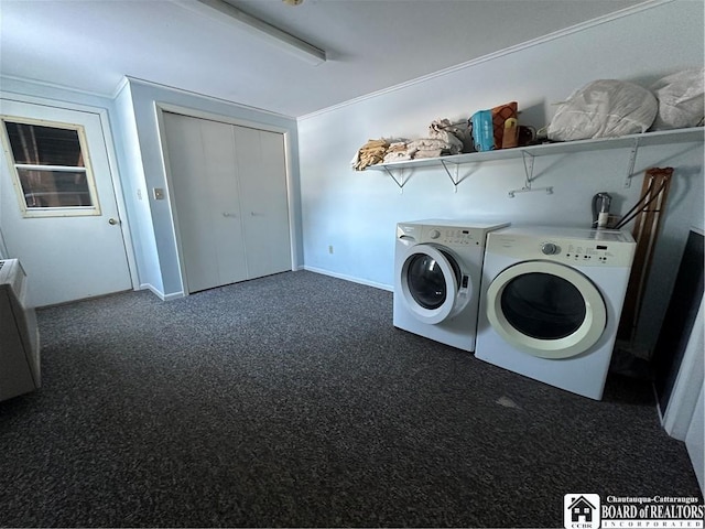 laundry room with crown molding, washing machine and clothes dryer, and dark carpet