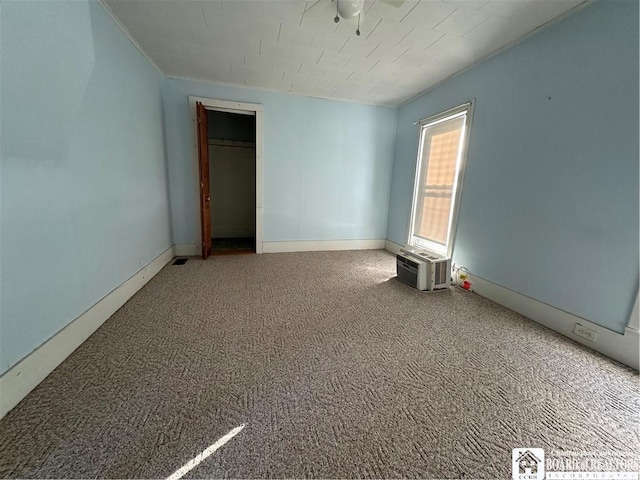 unfurnished bedroom with a wall mounted air conditioner and carpet flooring