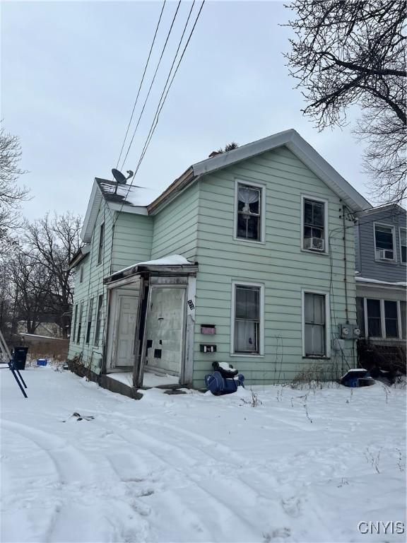 view of snow covered back of property