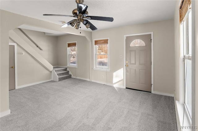 carpeted entrance foyer featuring ceiling fan