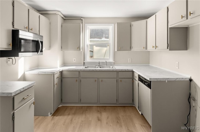 kitchen featuring stainless steel appliances, sink, light hardwood / wood-style flooring, and gray cabinets