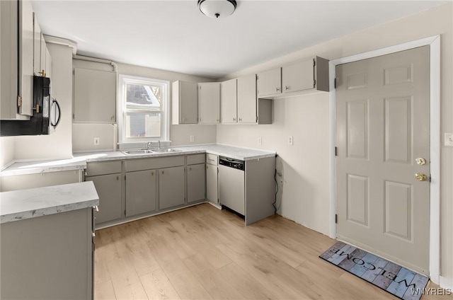 kitchen featuring light wood-type flooring, dishwasher, sink, and gray cabinetry