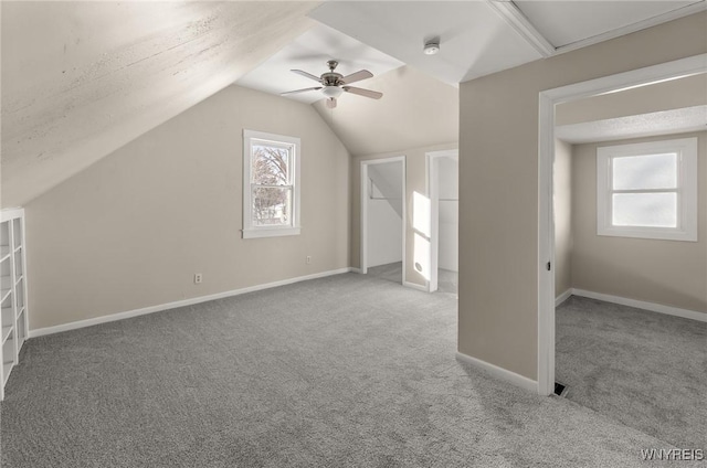 bonus room with light carpet, lofted ceiling, and ceiling fan