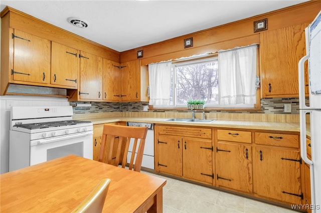 kitchen with white appliances, range hood, sink, and decorative backsplash