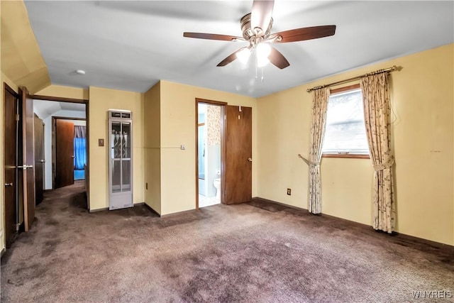 unfurnished bedroom featuring dark carpet, vaulted ceiling, and ceiling fan