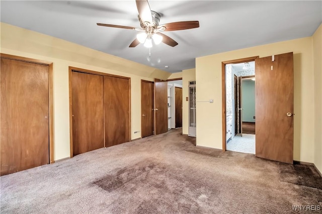 unfurnished bedroom with ceiling fan, carpet floors, and two closets