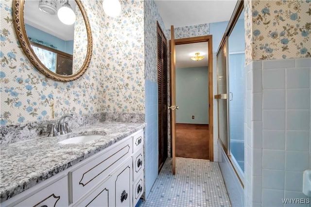 bathroom with enclosed tub / shower combo, vanity, and tile patterned flooring