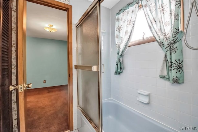 bathroom with shower / bath combination with glass door