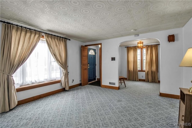 spare room featuring carpet and a wealth of natural light