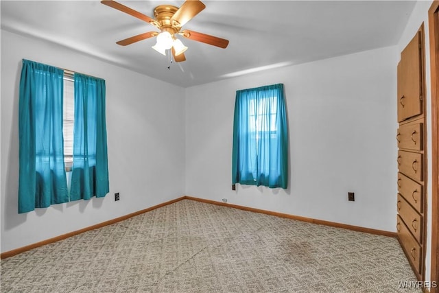 carpeted spare room featuring ceiling fan