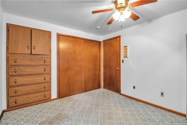 unfurnished bedroom featuring a closet, ceiling fan, and carpet flooring