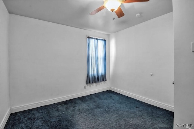 spare room with dark carpet and ceiling fan