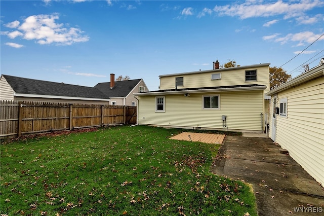 back of house with a yard and a patio