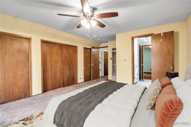 bedroom featuring multiple closets, ceiling fan, and light carpet