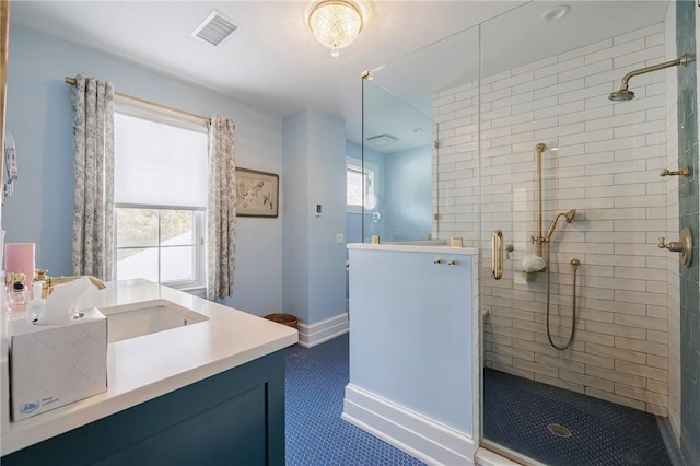 bathroom featuring vanity, plenty of natural light, and a shower with shower door