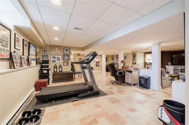 workout room with a drop ceiling, a baseboard heating unit, and ornate columns