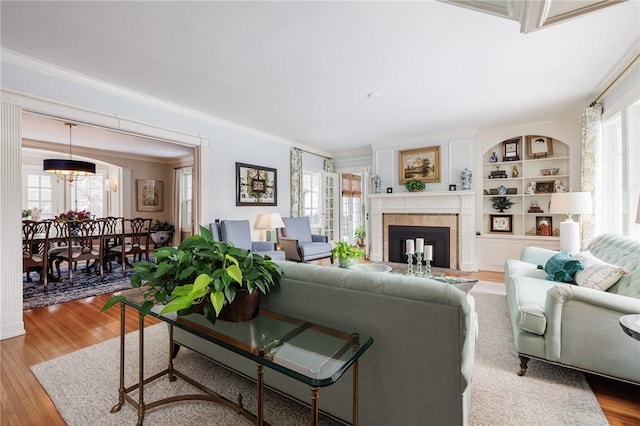 living room featuring crown molding, a notable chandelier, and light wood-type flooring