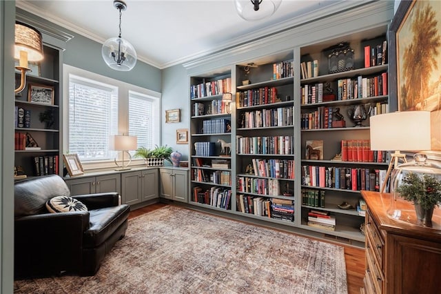 sitting room with crown molding and wood-type flooring